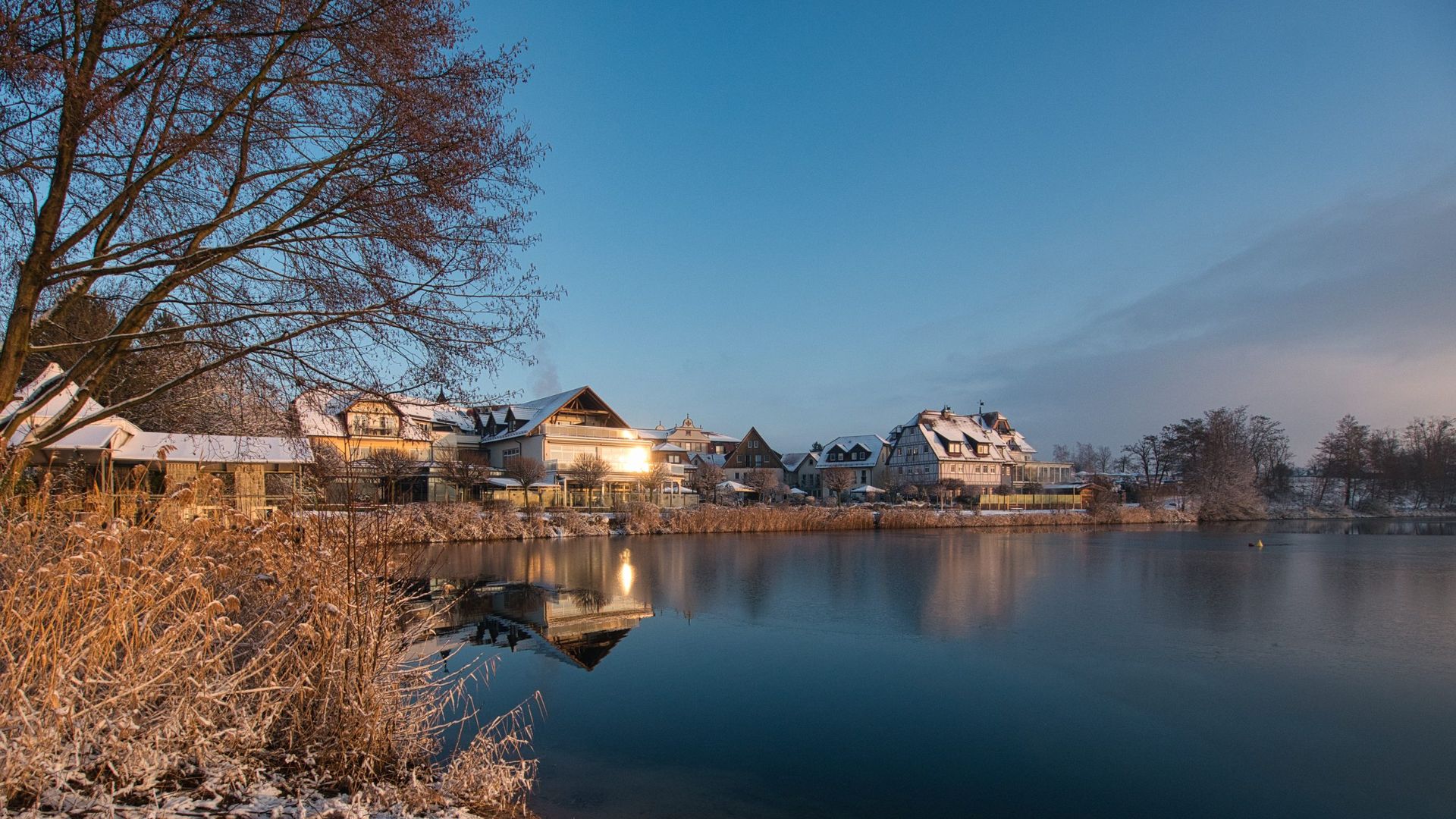Seehotel Niedernberg im Winter – Häuser am Ufer zur blauen Stunde